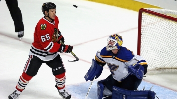 Andrew Shaw #65 of the Chicago Blackhawks watches as the puck sails over Brian Elliott #1 of the St. Louis Blues.