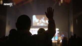A worshipper raises his hand during a Sunday morning service at Expectation Church in Virginia.