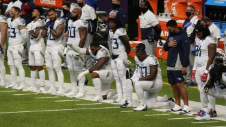 Members of the Tennessee Titans take part in the national anthem before an NFL football game against the Minnesota Vikings.