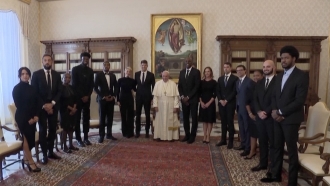 Pope Francis poses for a photo with NBA players at the Vatican.