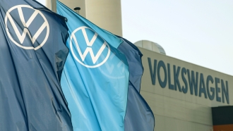 Flags wave in front of a VW Volkswagen factory building