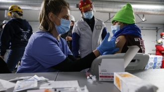 A worker receives a COVID-19 vaccine