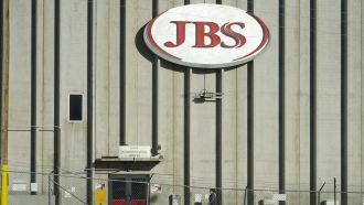 Worker walking into a JBS meatpacking plant.