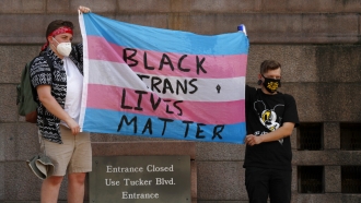 People hold a flag saying "Black Trans Lives Matter"