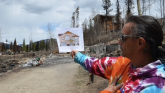 Man holds up a house rendering.