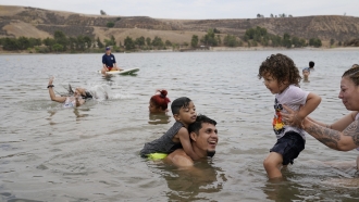 Members of the Romero family, visiting from Houston, cool off at Castaic Lake as temperatures rise in Castaic, Calif.
