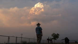 Person watches a plume of smoke from the Bootleg Fire near Bly, Oregon.