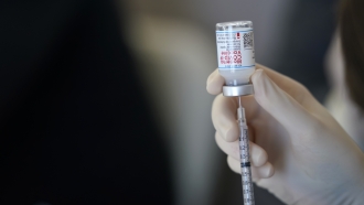 Provider fills syringe with vaccine
