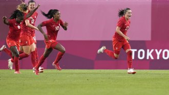 Canada's Jessie Fleming, right, celebrates scoring the opening goal from the penalty spot during a women's semifinal match.