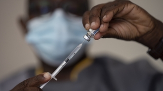 Health worker filling a syringe with a dose of a COVID-19 vaccine.
