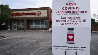 An information sign regarding COVID-19 vaccines is seen outside of a CVS store in Chicago, Ill.