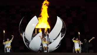Japanese athletes wave after lighting the Paralympic cauldron.