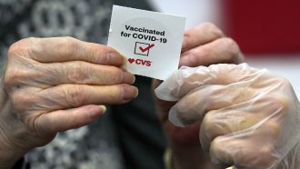 A patient receives a sticker after receiving a shot of a COVID-19 vaccine at a CVS Pharmacy