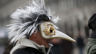 A man wears a pest doctor mask in St. Mark's Square in Venice, Italy.