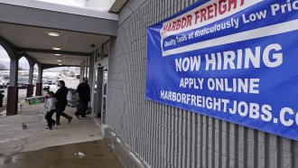 a "Now Hiring" sign hangs on the front wall of a Harbor Freight Tools store