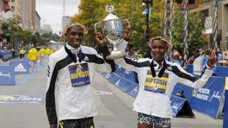 Kenyans Benson Kipruto and Diana Kipyogei celebrate winning the men's and women's division of the 125th Boston Marathon.