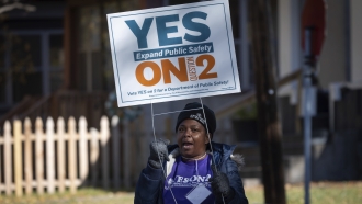 A volunteer holds a Vote Yes sign