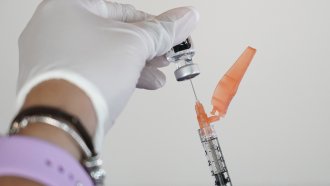 A nurse loads a syringe with the Pfizer COVID-19 vaccine