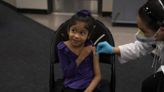 A six year old prepares to receive the Pfizer COVID-19 vaccine