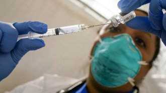 Doctor extracts Pfizer vaccine from a vial