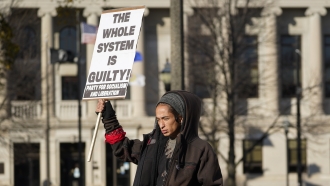 A protestor stands near of the Kenosha County courthouse in Kenosha, Wisconsin
