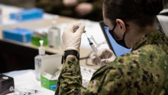 A U.S. Navy Sailor prepares a COVID-19 vaccine
