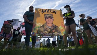 Protesters hold a poster depicting Vanessa Guillen.