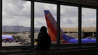 A passenger walks past a Southwest Airlines plane at an airport