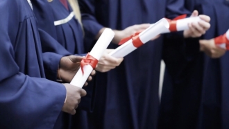 Graduates hold diplomas.