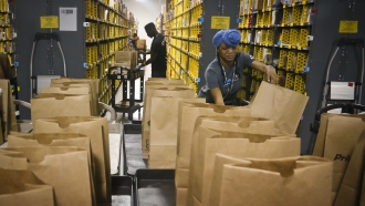 Amazon employees setting up packages.