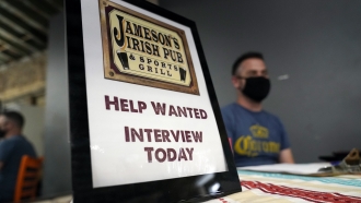 A hiring sign is shown at a booth for Jameson's Irish Pub during a job fair in Los Angeles