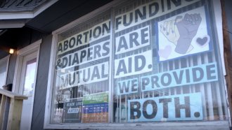 Signs show through an abortion clinic's window.