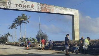 People clear debris off the street in Nuku'alofa, Tonga