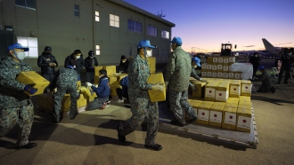 Japan's Air Self-Defense Force load boxes of water into airplane