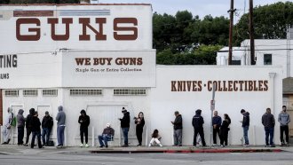 People wait in line to enter a gun store.