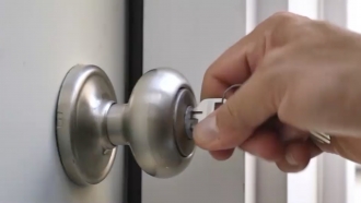 Someone turning a key to unlock a door