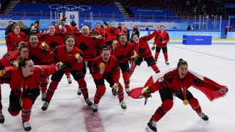 Canada players celebrate with their gold medals after the women's gold medal hockey game at the 2022 Winter Olympics