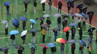 Residents in Hong Kong line up in the rain to get tested for the coronavirus