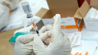 A registered nurse fills a syringe with the Johnson & Johnson COVID-19 vaccine