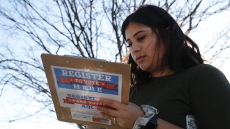 A college student fills out a voter registration form