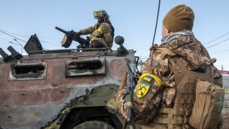 Ukrainian soldiers inspect a damaged military vehicle after fighting in Kharkiv, Ukraine.