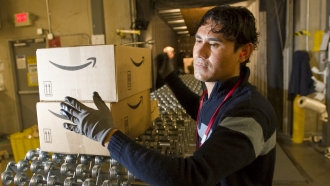 An Amazon employee grabs boxes to be loaded onto a truck