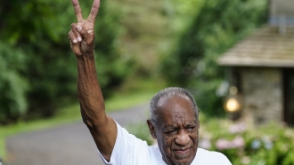 Bill Cosby gesturing outside his home