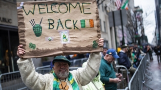 A man holds a poster during the St. Patrick's Day Parade