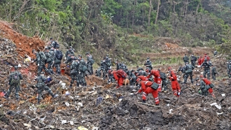 Rescue workers search for black boxes at the scene of a plane crash.