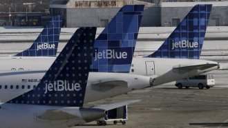 JetBlue planes wait at terminal gates