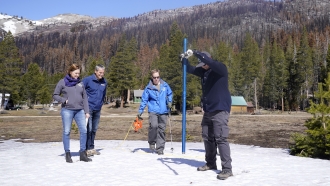 A California Department of Water Resources employee measures a snowpack.
