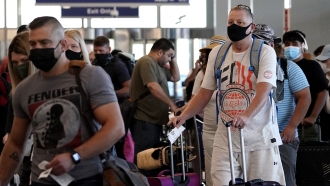Travelers wear face masks in an airport