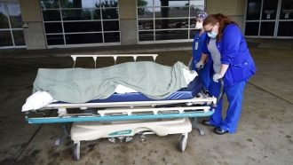 Medical staff prepare to move the body of a deceased COVID-19 patient.