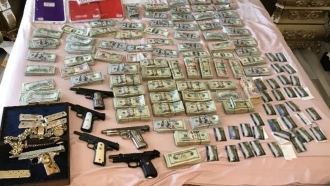 Cash, debit cards and guns seized in an unemployment insurance fraud investigation.